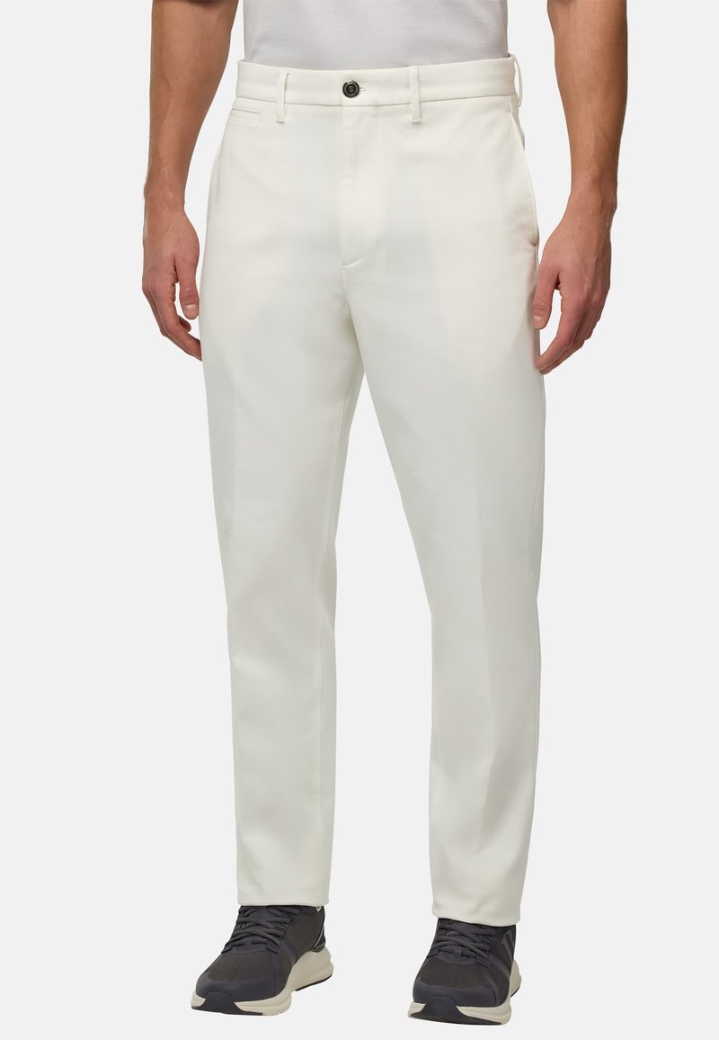 Pantalons blancs avec une coupe droite, fabriqués dans un matériau lisse ; ils disposent d'une fermeture à bouton à l'avant et de poches latérales.