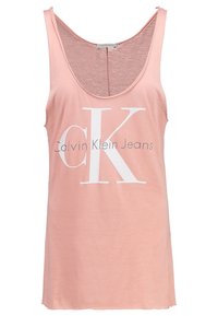 Ljusrosa linne i mjukt material, med en stor vit "CK"-logotyp och texten "Calvin Klein Jeans" under. Rundad halsringning och sprund på sidorna.