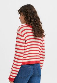 Maglione a righe rosse e crema con orlo e polsini a coste, caratterizzato da una vestibilità comoda e una texture lavorata a maglia. Vista dal retro.