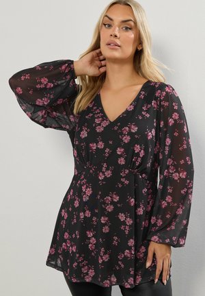 Blusa negra con flores y mangas largas abullonadas. Presenta un escote en V y está adornada con pequeñas flores rosas. Fabricada en una tela ligera y semitranslúcida.