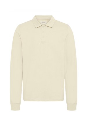 Vaaleanbeige pitkähihaista poolopaitaa, valmistettu pehmeästä puuvillasta. Siinä on klassinen kaulus, napillinen edestä ja resorit hihansuuissa.