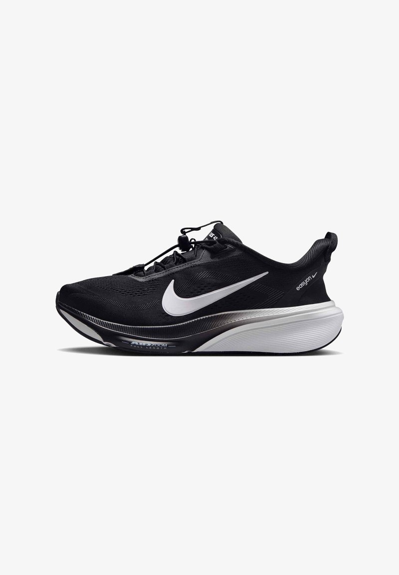 Μαύρο αθλητικό παπούτσι Nike με λευκό λογότυπο swoosh, παχιά λευκή και μαύρη σόλα, θηλιά έλξης και σύστημα γρήγορου κορδονιού σε λευκό φόντο.