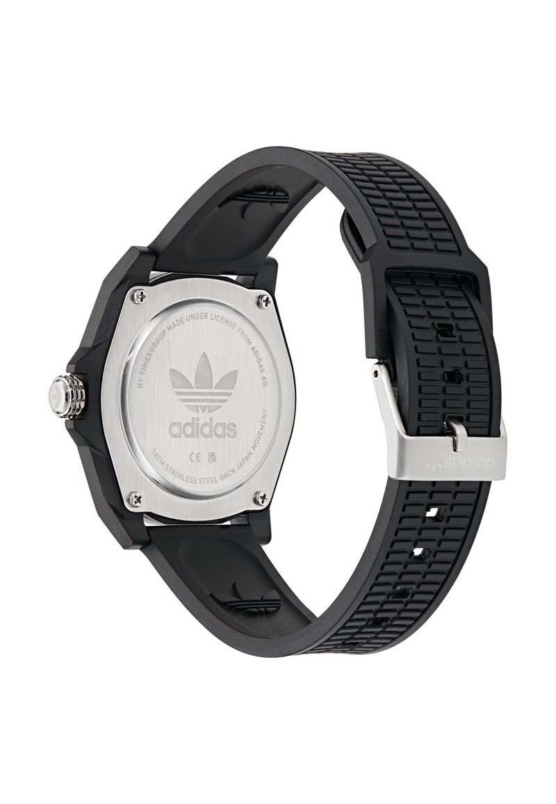 Montre de sport en caoutchouc noir avec un dos de boîtier en acier inoxydable hexagonal. Bracelet texturé et garnitures argentées, arborant le logo Adidas.