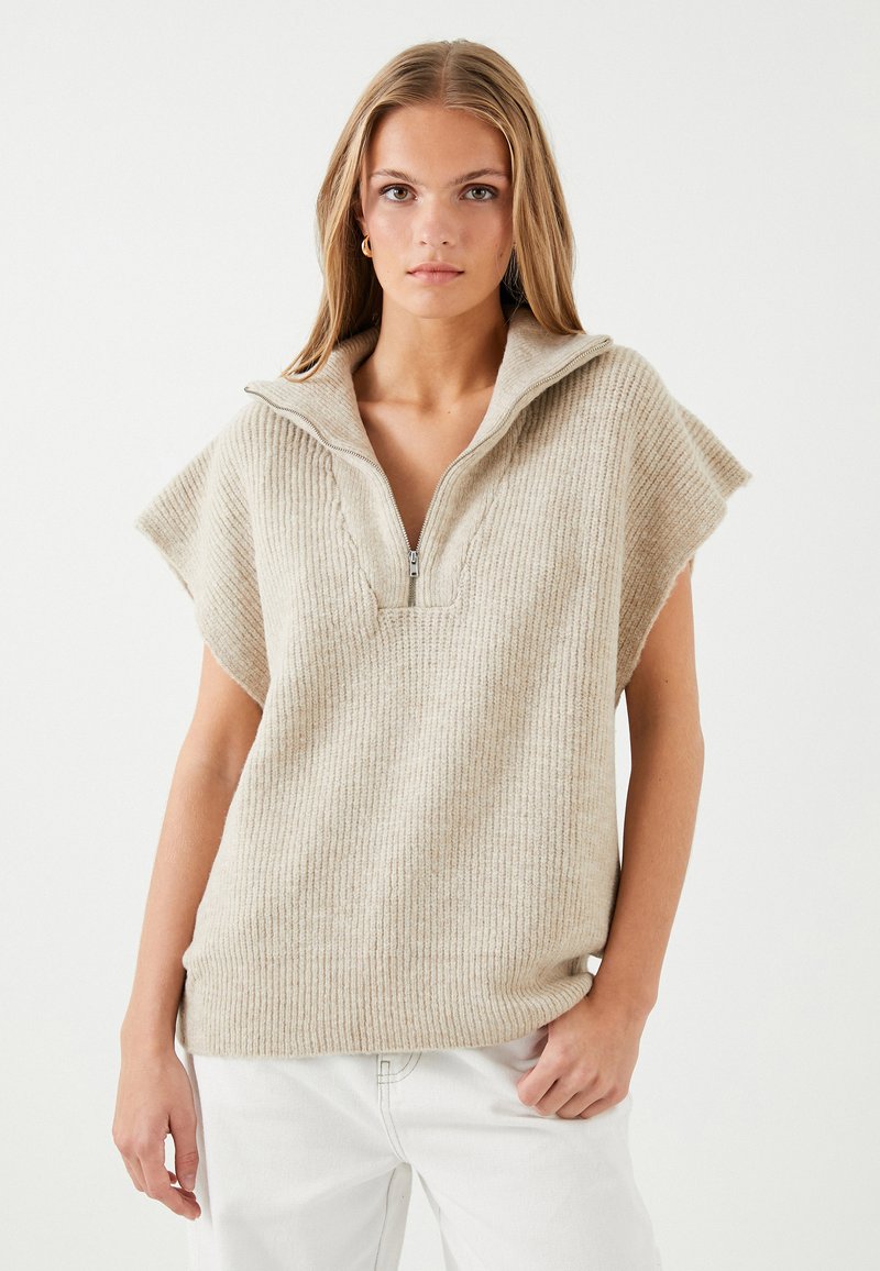 Beige, ribbet sweater med halv-lynlås krave og brede ærmer. Tekstureret stof med en afslappet pasform, designet til lagtydning.