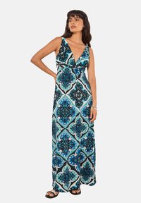 Maxi-jurk met een diepe V-hals, een meerkleurig geometrisch patroon in blauw, zwart en teal, gemaakt van een vloeiende stof en met een enkel-lang model.