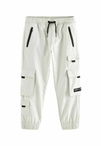 Pantalons cargo gris clair avec une taille élastique, poches à cuisse zippées et bas élastiques. Dotés d'accents noirs et d'un détail de label.