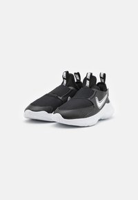 Black athletic shoes with mesh and synthetic material, elastic slip-on design, white Nike Swoosh, and textured rubber outsole.
