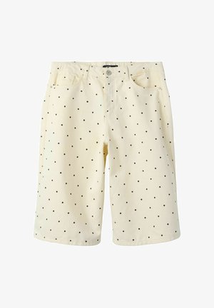 Pantalones cortos hasta la rodilla de color crema con lunares negros, botón delantero, cremallera y diseño de cinco bolsillos.