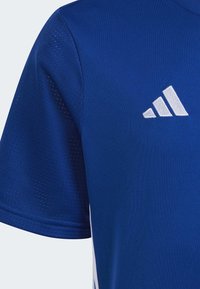 Camiseta deportiva azul de mangas cortas, fabricada con un tejido transpirable, con un logo blanco de Adidas y paneles laterales texturizados.