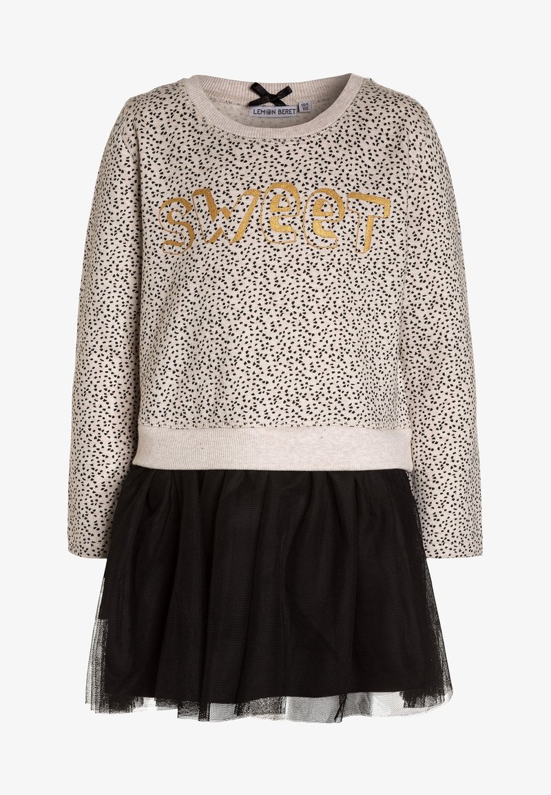 Robe beige à manches longues avec des taches noires, texte doré « sweet » sur la poitrine, et jupe en tulle noir attachée.