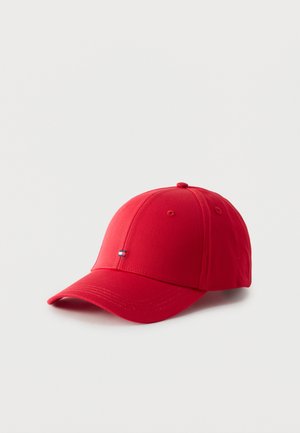 Rød baseballkasket med lille rektangulært logo med blå, hvide og røde striber foran, sat mod en ensfarvet hvid baggrund.