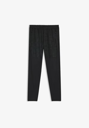 Black athletic pants with a textured panel featuring a grid pattern at the top. Designed with an elastic waistband and zippered pockets.