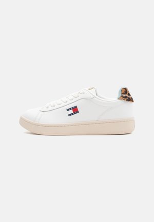 Sneaker sintetica bianca con punta arrotondata, suola beige, logo Tommy Jeans sul lato e un accento in stampa leopardo sul tallone.