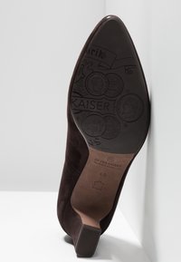 Chaussure à talon haut en daim marron à bout pointu, montrant la semelle avec des motifs de pièces embossées et la taille 4½ par Peter Kaiser.