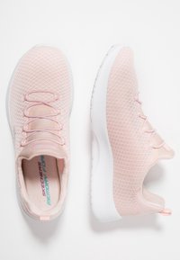Jasnoróżowe buty sportowe z siateczkową cholewką, zaokrąglonym noskiem i białą gumową podeszwą. Charakteryzują się teksturowanym wzorem oraz elastycznymi sznurowadłami zapewniającymi pewne dopasowanie.