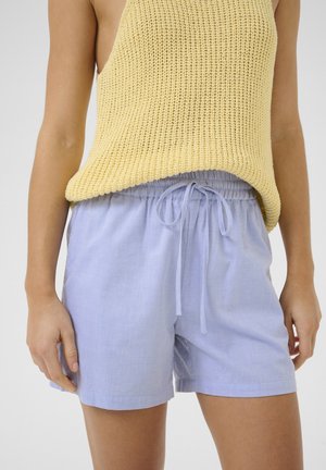 Top in maglia gialla abbinato a pantaloni corti azzurri chiari con vita elastica e lacci, che offrono una vestibilità comoda.