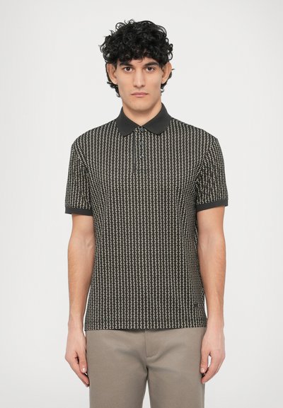 Polo à manches courtes noir et beige avec un motif géométrique, col plat et patte de boutonnage à trois boutons. Le tissu semble lisse et léger.