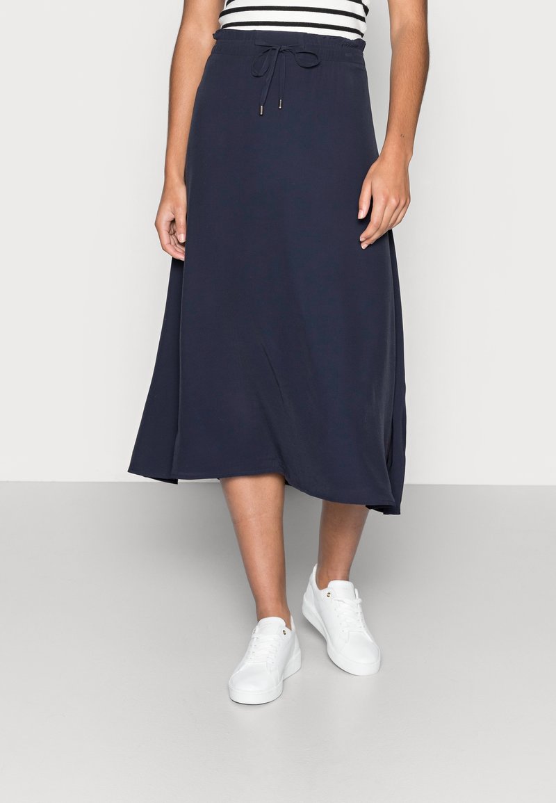Navy midi skirt made of soft fabric, featuring an elastic waistband with a drawstring detail, and a relaxed, flowing silhouette.