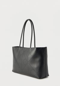 Μαύρη ορθογώνια τσάντα ώμου με διπλές λαβές και διακοσμητικά διάτρητα σχέδια σε σχήμα σπείρας και ρόμβου σε λεία δερμάτινη επιφάνεια.