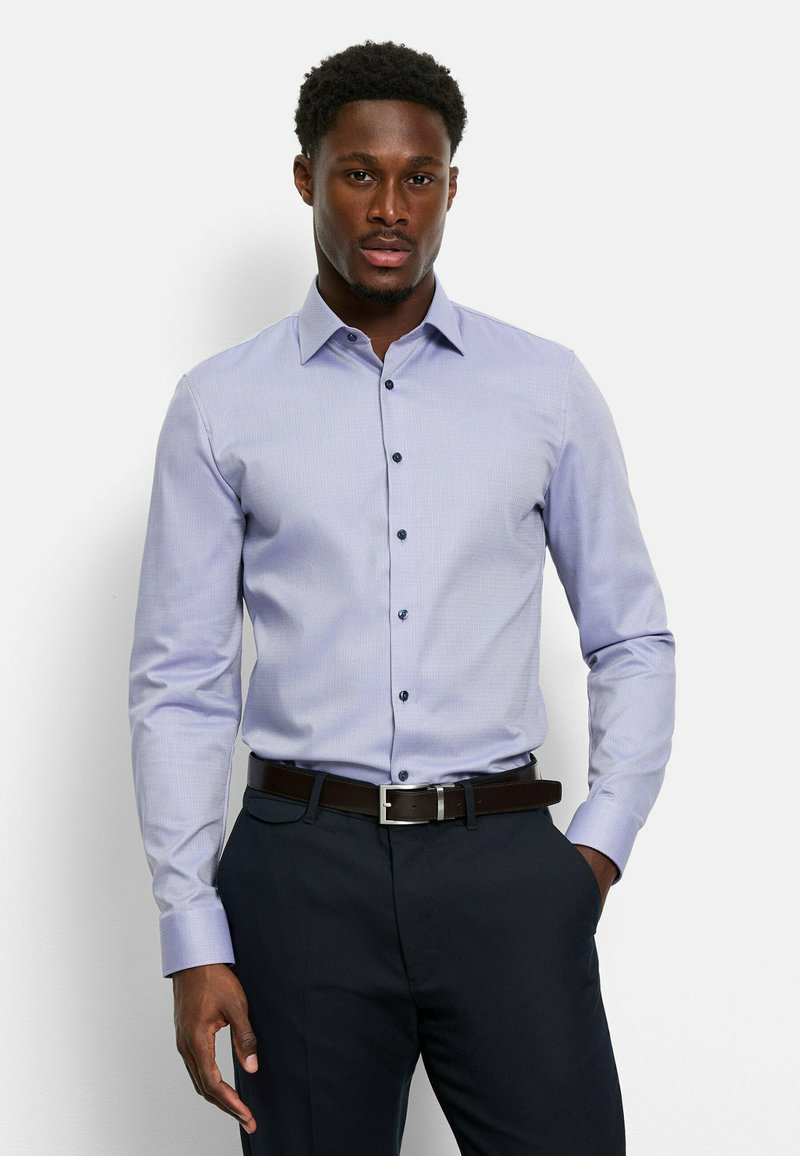 Light purple button-up shirt with a subtle check pattern, long sleeves, dark buttons, and a collar, paired with dark trousers and a brown belt.