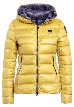 Chaqueta acolchada amarilla con capucha, cremallera negra, dos bolsillos laterales con cremallera y un pequeño parche con el logo negro en el pecho y la manga.