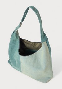 Hobo-väska i tvåtonsfärgad denim i ljus och mörk teal. Har ett handtag, dragkedjestängning och en innerficka. Strukturerad tyg.