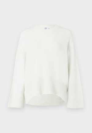 Hrubý biely sveter s rebrovaným lemom a manžetami, okrúhlym výstrihom a spustenými ramenami. Mäkká štruktúra, voľný strih a nadmerný dizajn.