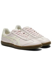 Light pink sneakers made of leather with a textured finish. Features white accents and a rubber sole. Rounded shape with laces.