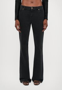 Black flared jeans with a high waist, gold button hardware, two front pockets, and a smooth denim texture.