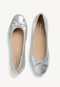Ballerine in pelle argentata con punta arrotondata, fiocco decorativo e interno imbottito con perforazioni per la traspirabilità.