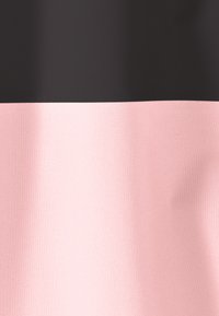 De stof heeft twee horizontale strepen: een donkerzwarte bovenste sectie en een zachte roze onderste sectie, beide met een textuurrijke, geweven uitstraling.