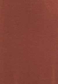 Tkanina barvy rezavého odstínu s hladkou strukturou, obsahující jemný melírovaný vzor. Materiál působí měkce a lehce, vhodný pro běžné nošení.