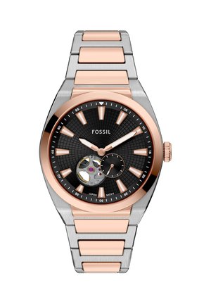 Montre-bracelet Fossil avec cadran noir, bracelet métallique en or rose et argent, affichage open-heart, index des heures en or rose et petit cadran des secondes.