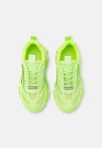 Neonowe zielone sneakersy z siateczkowymi panelami, okrągłym noskiem, sznurowanym wykończeniem oraz pętelką na pięcie. Teksturowane akcenty wzdłuż boków.