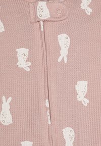Cardigan lavorato a maglia rosa con motivi di coniglietto bianco, dotato di una cerniera frontale e di una chiusura a pressione rotonda. Tessuto testurizzato con design a coste.