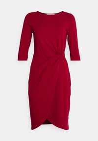 Rotes knielanges Kleid mit drei Viertelärmeln, rundem Ausschnitt und einem gerafften KnotenDetail an der Taille, das einen Tulpen-Saum bildet.