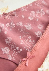 Tissu mauve avec des dessins linéaires blancs de femmes tenant des tournesols et entourées de motifs floraux, avec de petits nœuds assortis sur les bords.