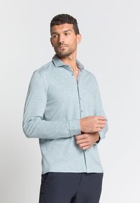 Lichtblauwe lange mouwen shirt met een kraag, knoopsluiting aan de voorkant en een licht gestructureerde stof. Aansluitend ontwerp met een casual uitstraling.