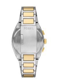 Stainless steel watch with silver and gold-tone accents. Features a brushed finish, smooth links, and a clasp engraved with "FOSSIL."
