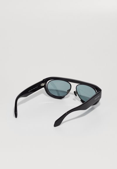 Ochelari de soare negri cu lentile în nuanțe de albastru se află pe un fundal alb simplu, evidențiind designul lor elegant și finisajul lucios.