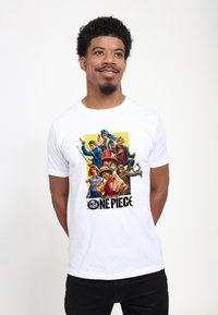 Bílé bavlněné tričko s barevným grafikou zobrazující více postav z "One Piece" s tučným černým textem pod ilustrací.