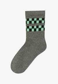 Sive bombažne nogavice z šahirnim vzorcem v črni in minzij zeleni barvi na zgornjem delu; gladka tekstura in tradicionalna oblika.