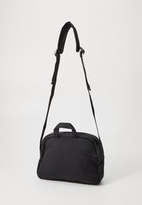 Borsa a tracolla nera con tracolla imbottita, manico superiore, chiusura con zip e texture liscia. Forma rettangolare compatta, adatta per l'uso quotidiano.
