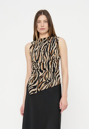 Mujer con top sin mangas de rayas de tigre con detalle fruncido lateral y falda negra, de pie sobre fondo blanco.
