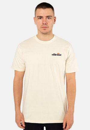 T-shirt court à manches courtes crème en coton avec un col rond, arborant un logo "ellesse" noir et un graphique coloré de soleil sur la poitrine.