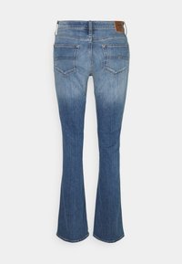 Jean flare en denim bleu avec taille mi-haute, cinq poches et une étiquette de marque en cuir marron contrastant sur la ceinture arrière.