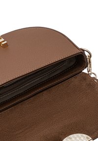 Innenansicht einer braunen Lederhandtasche mit goldenen Beschlägen, einer Reißverschlusstasche und weichem Stofffutter. Enthält glatte und strukturierte Oberflächen.