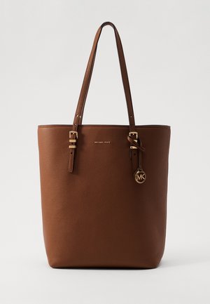 Brązowa skórzana torba typu tote Michael Kors z podwójnymi regulowanymi paskami i złotym wisiorkiem z logo MK na pasku.