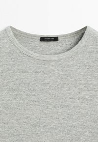 Hellgrauer Pullover mit Rundhalsausschnitt, feiner gesprenkelter Textur und schwarzem Etikett mit der Aufschrift "Massimo Dutti Made in Morocco" am Halsausschnitt.