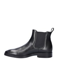 Zwarte leren Chelsea boots met elastische zijkanten, een gladde textuur, een spits toelopende neus en een platte rubberen zool. Voorzien van een lusje om gemakkelijk aan te trekken.